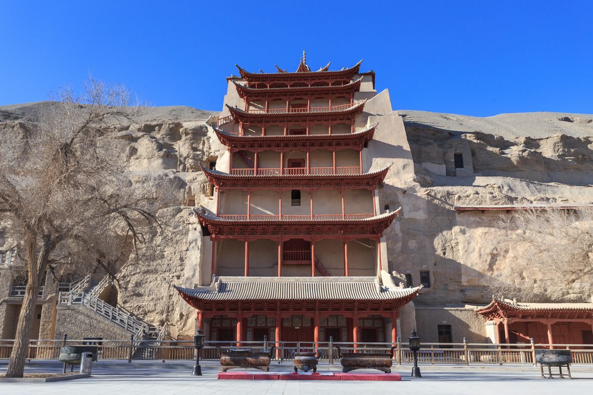 The cliff face of the Mogao Caves, with the nine-storey pagoda rising over the grottoes